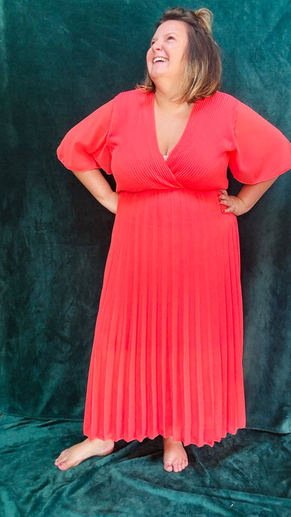 Avec cette robe longue grande taille plissée unie corail foncée, soyez prête à briller avec élégance et confort lors de toutes vos occasions spéciales. Idéale pour afficher votre style glamour et professionnel avec une pièce vibrante et sophistiquée.