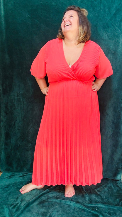 Avec cette robe longue grande taille plissée unie corail foncée, soyez prête à briller avec élégance et confort lors de toutes vos occasions spéciales. Idéale pour afficher votre style glamour et professionnel avec une pièce vibrante et sophistiquée.