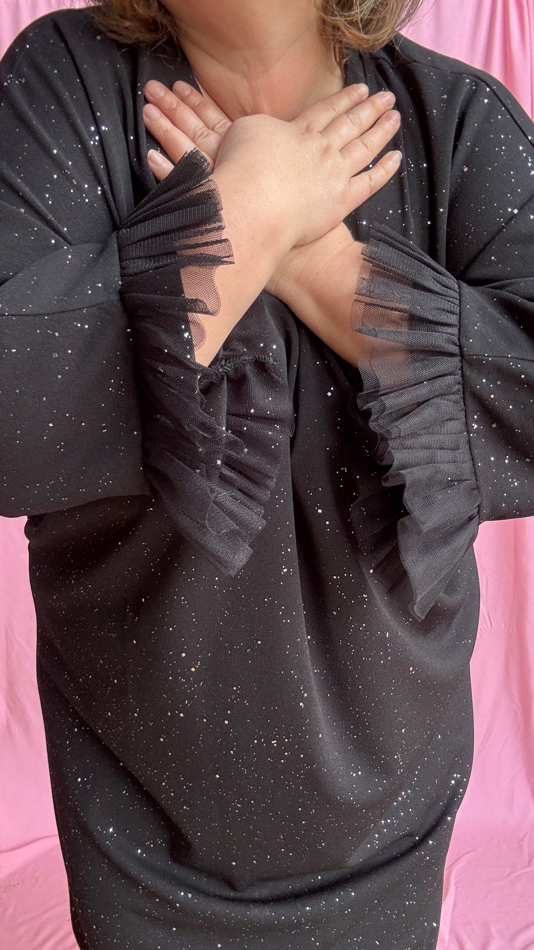 Une robe grande taille droite noir et paillettes manches évasées en froufrous pour un look arty glamour