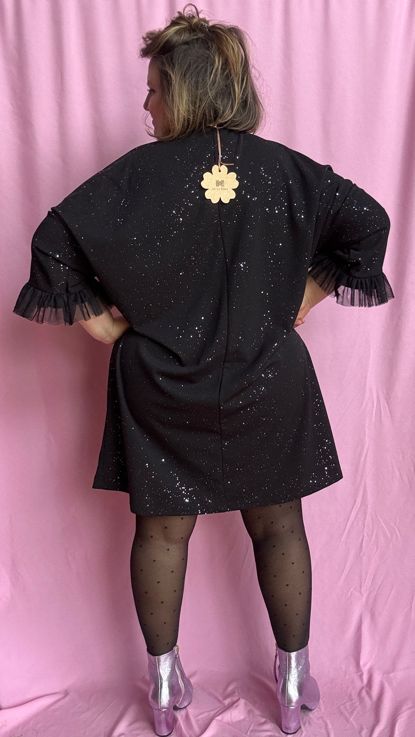 Une robe grande taille droite noir et paillettes manches évasées en froufrous pour un look arty glamour