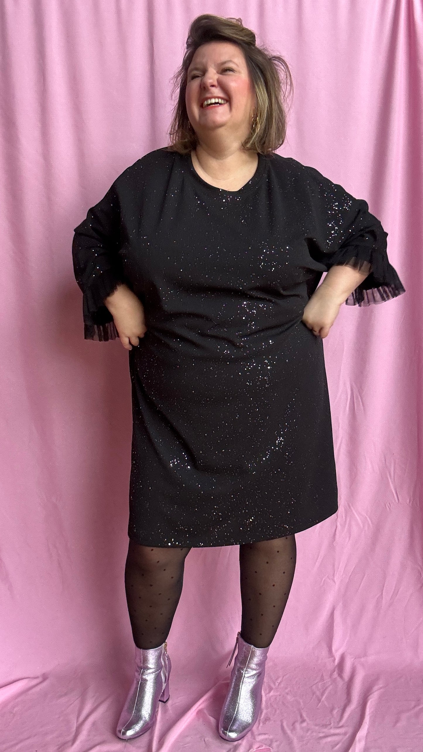 Une robe grande taille droite noir et paillettes manches évasées en froufrous pour un look arty glamour