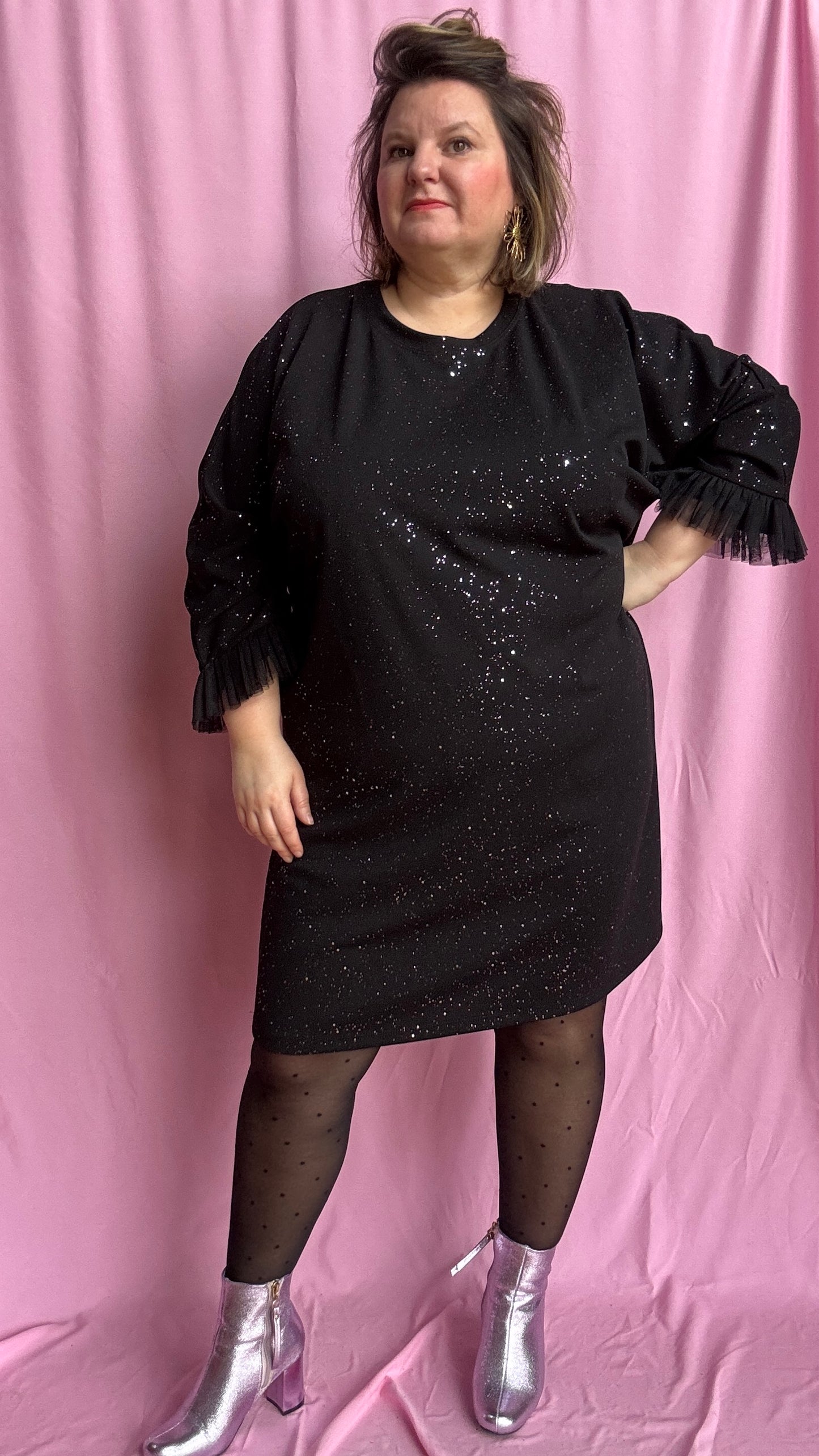Une robe grande taille droite noir et paillettes manches évasées en froufrous pour un look arty glamour