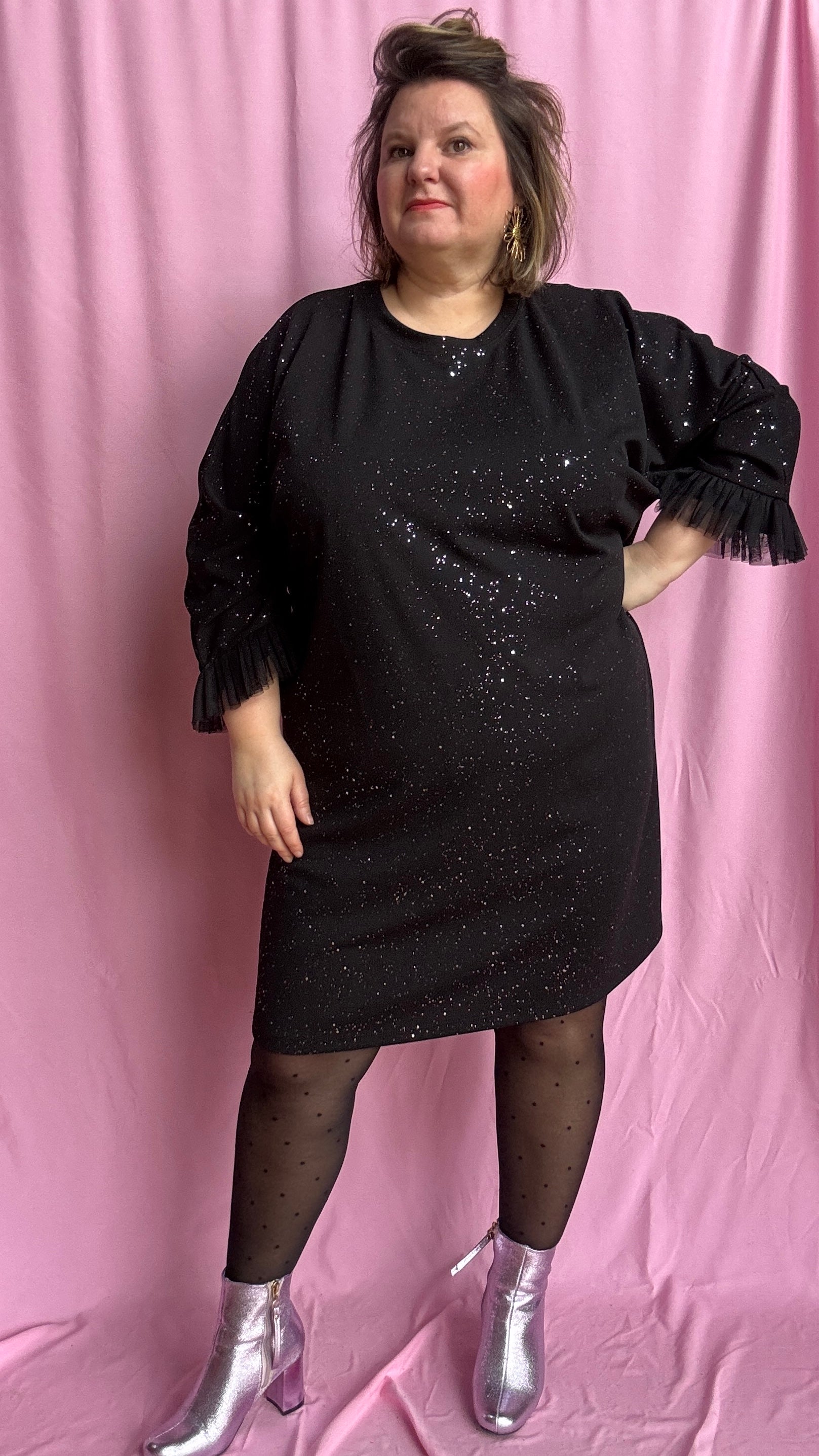 Une robe grande taille droite noir et paillettes manches évasées en froufrous pour un look arty glamour