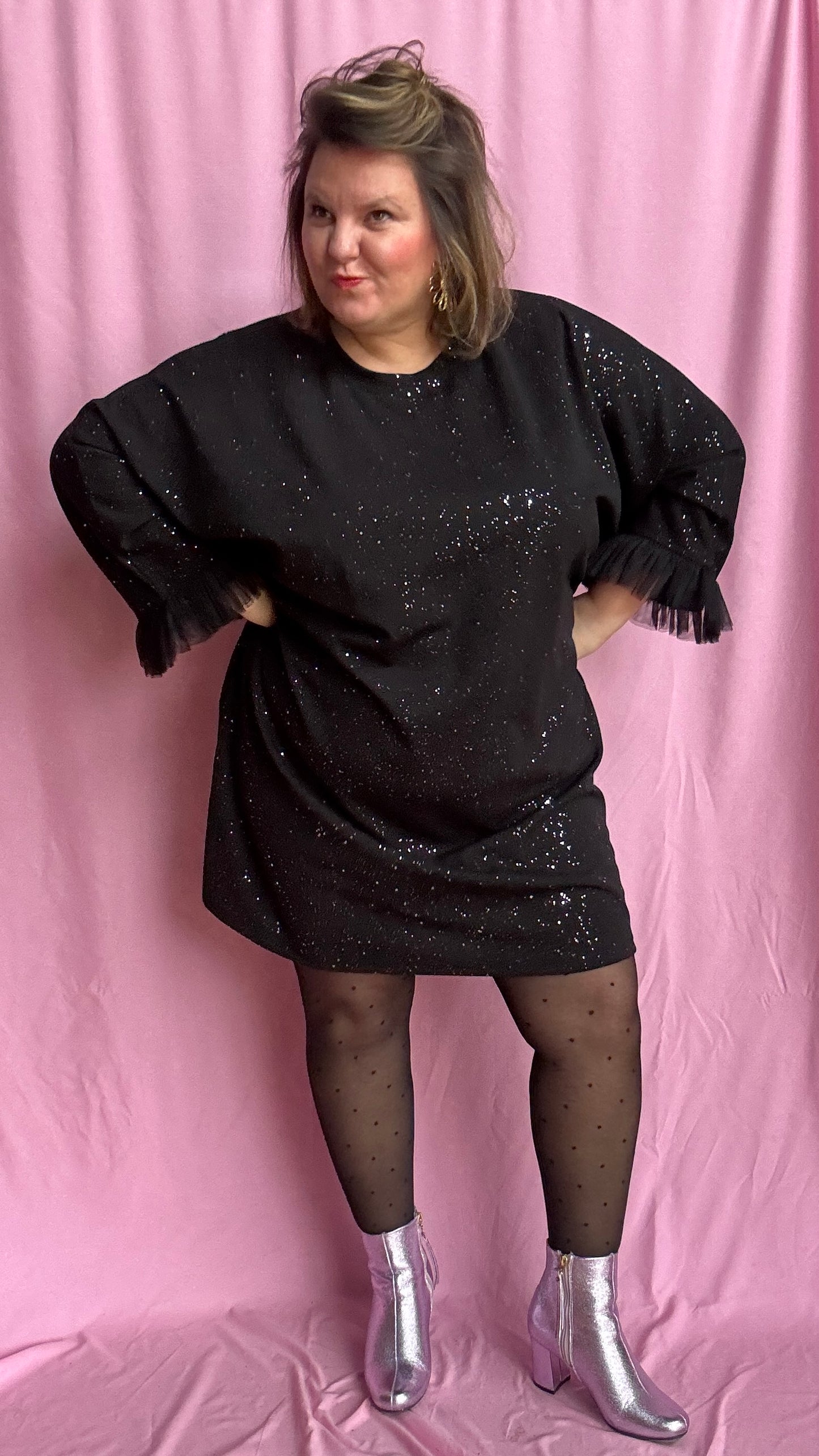 Une robe grande taille droite noir et paillettes manches évasées en froufrous pour un look arty glamour