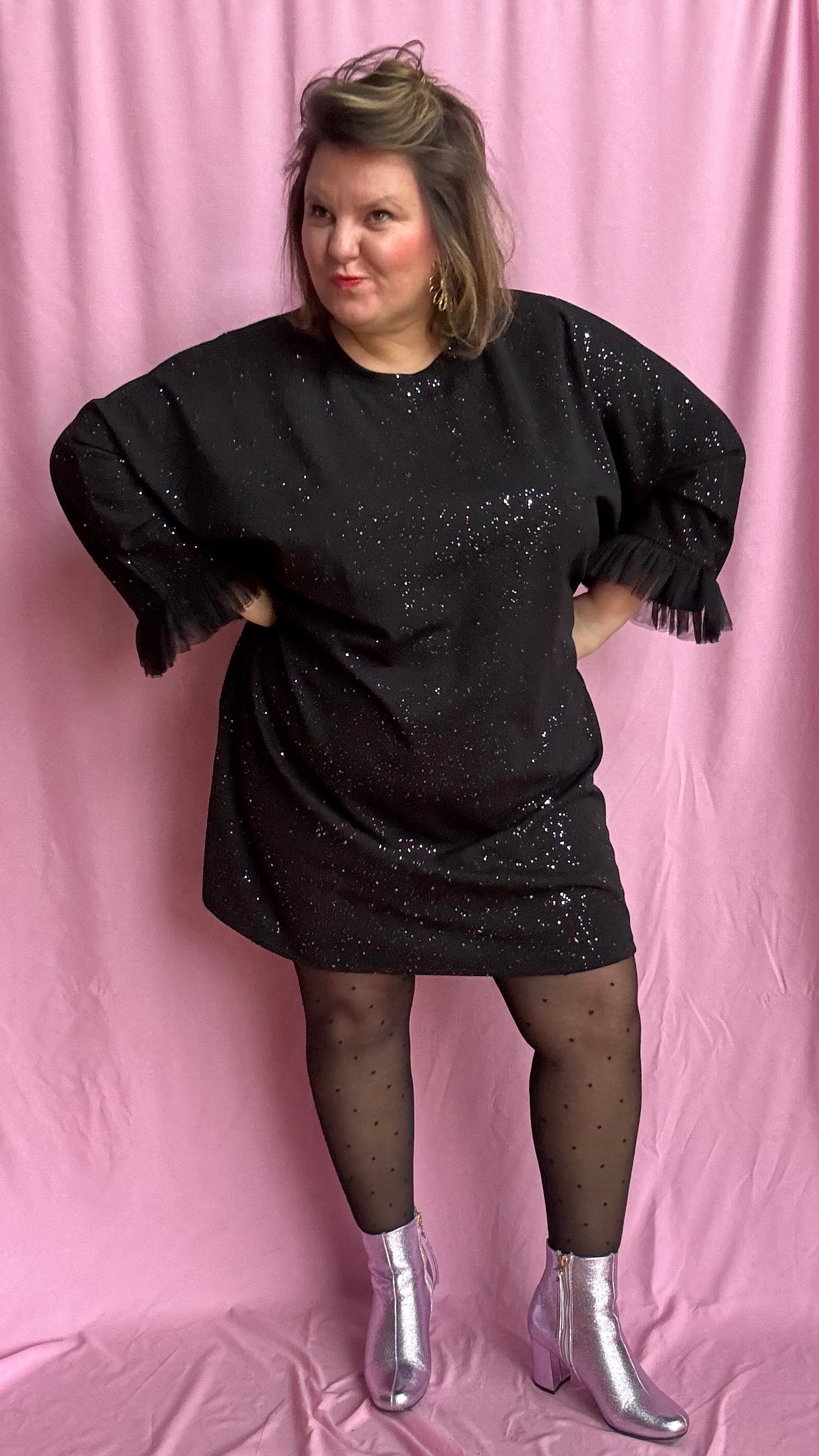 Une robe grande taille droite noir et paillettes manches évasées en froufrous pour un look arty glamour