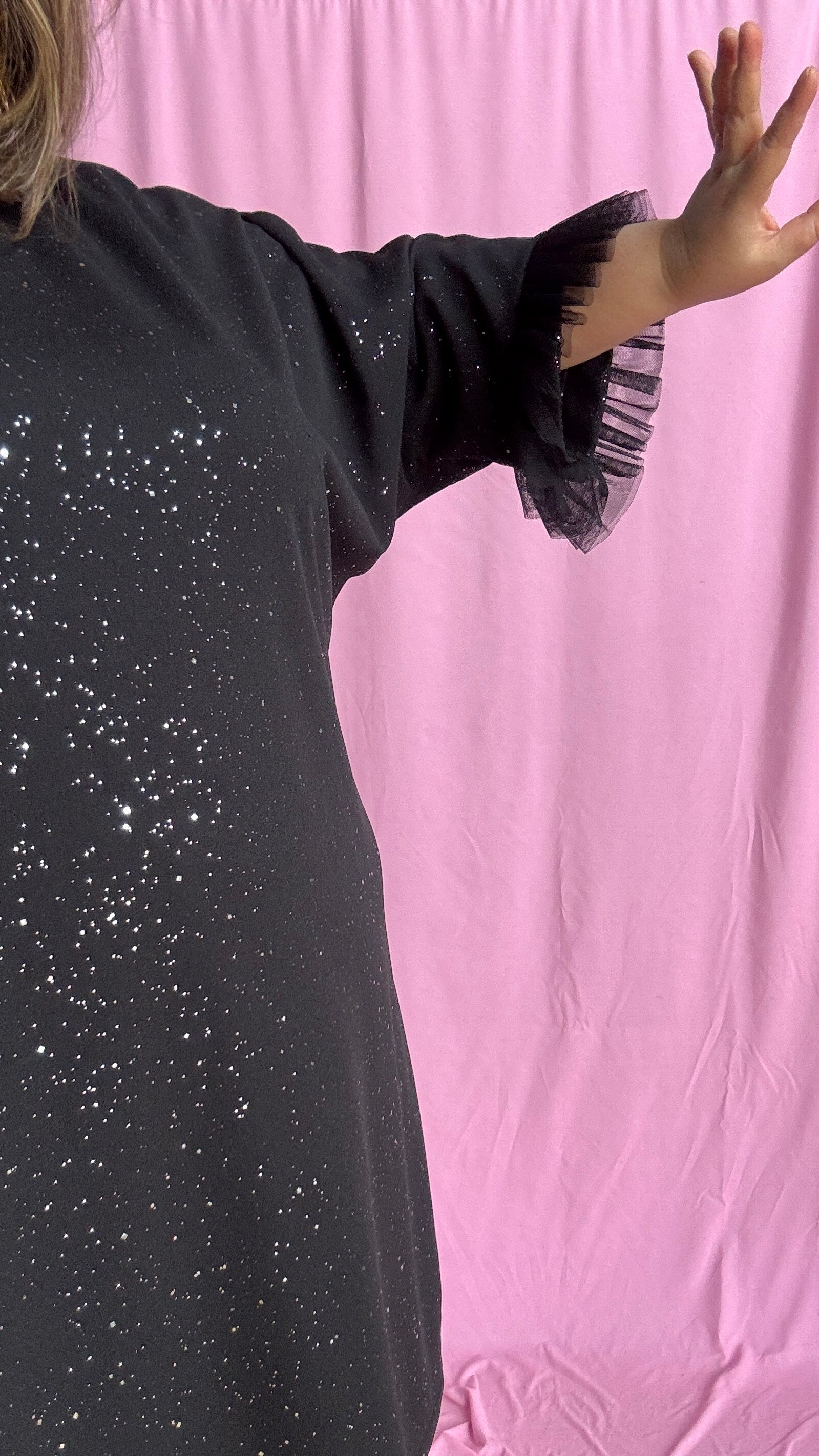 Une robe grande taille droite noir et paillettes manches évasées en froufrous pour un look arty glamour