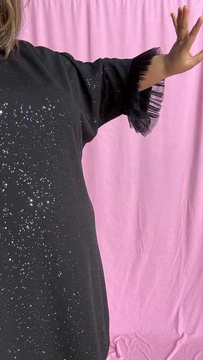 Une robe grande taille droite noir et paillettes manches évasées en froufrous pour un look arty glamour
