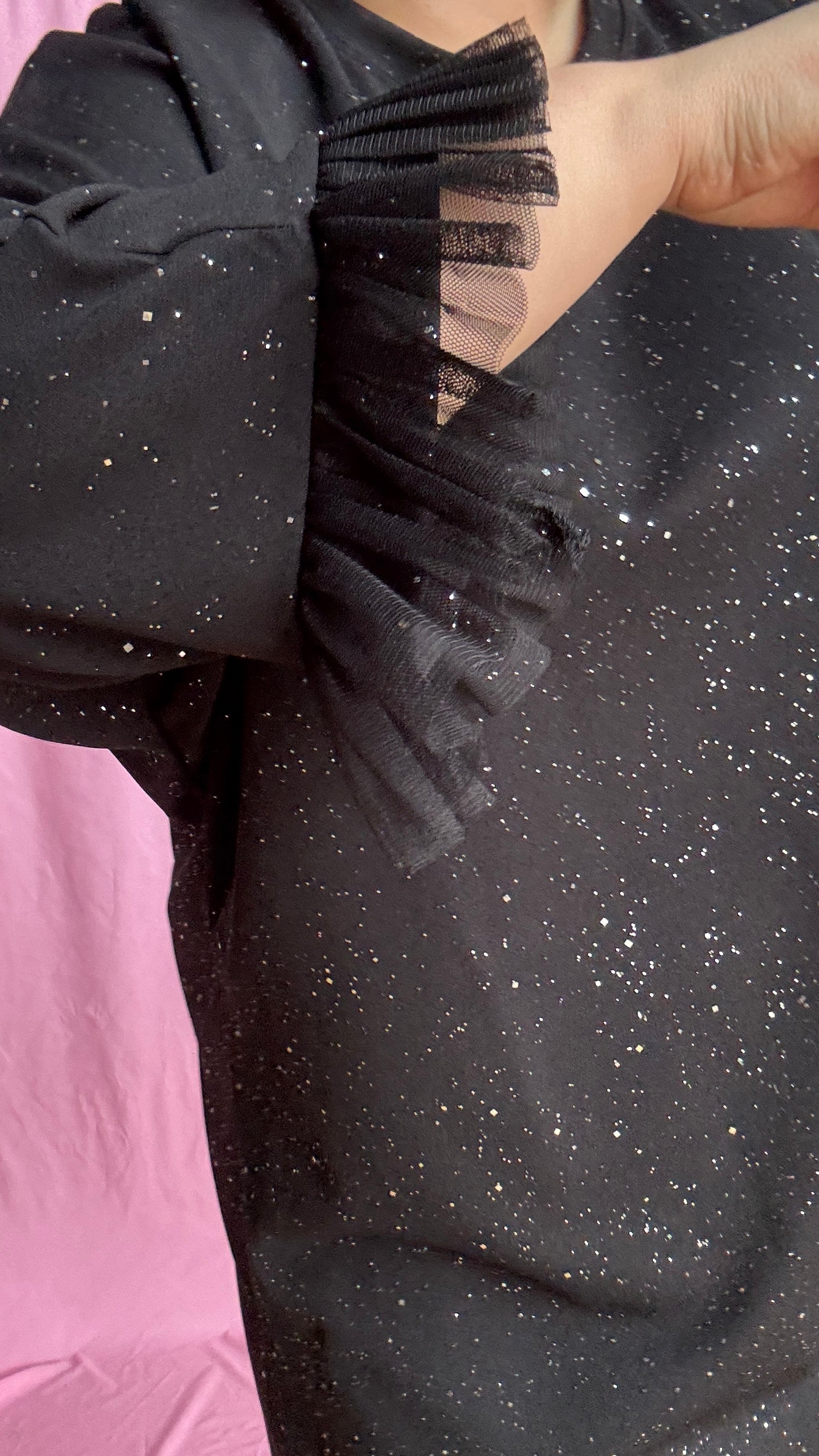 Une robe grande taille droite noir et paillettes manches évasées en froufrous pour un look arty glamour