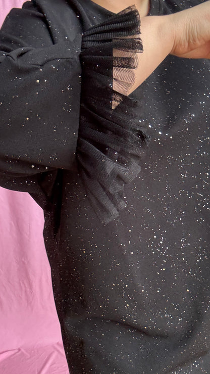 Une robe grande taille droite noir et paillettes manches évasées en froufrous pour un look arty glamour