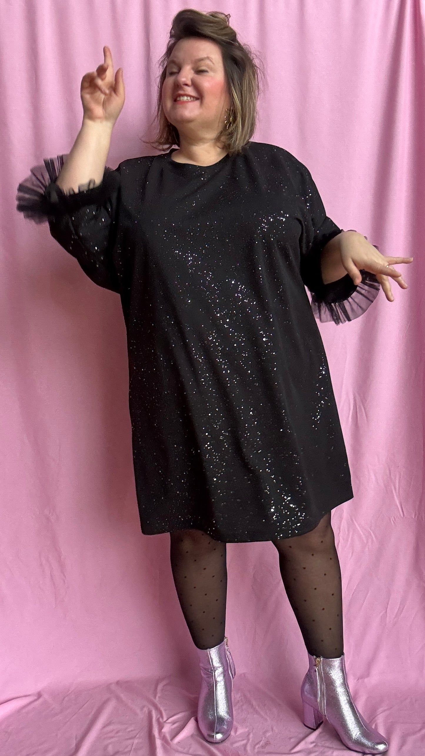 Une robe grande taille droite noir et paillettes manches évasées en froufrous pour un look arty glamour