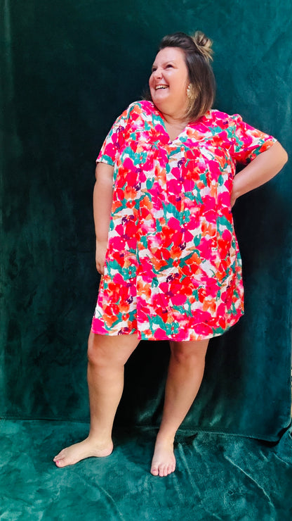 Avec cette robe courte grande taille à motifs fleuris colorés, soyez prête à afficher un style audacieux et confortable en toute occasion. Parfait pour les femmes qui aiment allier élégance et praticité dans leur garde-robe estivale.