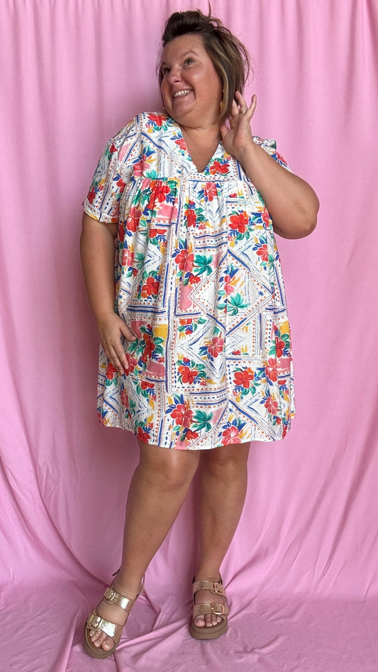 Une pièce ingénieuse et ultra stylée : cette robe-short grande taille aux motifs fleuris rouge vert bleu et jaune associe le confort d’un short à la féminité d’une robe courte droite