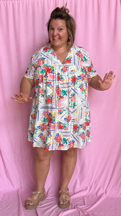 Une pièce ingénieuse et ultra stylée : cette robe-short grande taille aux motifs fleuris rouge vert bleu et jaune associe le confort d’un short à la féminité d’une robe courte droite