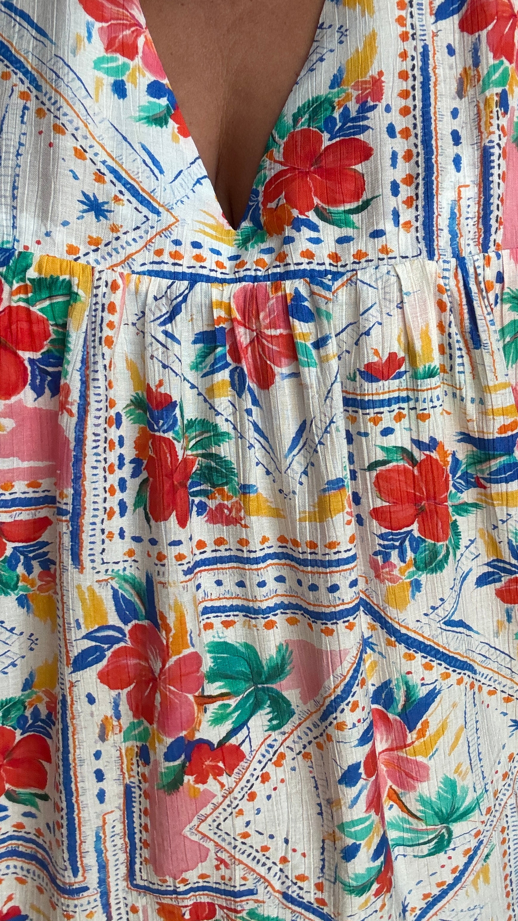 Une pièce ingénieuse et ultra stylée : cette robe-short grande taille aux motifs fleuris rouge vert bleu et jaune associe le confort d’un short à la féminité d’une robe courte droite