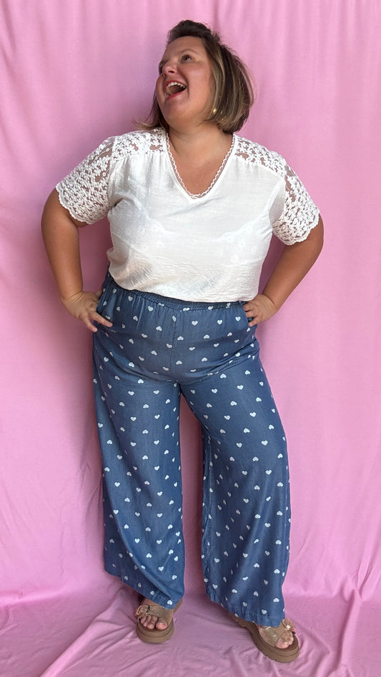 Un top grande taille blanc à la fois élégant, original et facile à porter avec broderie en transparence bras et dos.