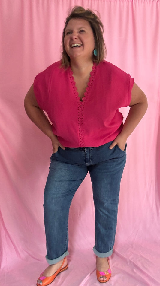Ce top uni rose fuchsia met en valeur la silhouette avec son magnifique décolleté en V bordé de dentelle délicate